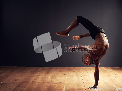 Image of Dedication, passion, commitment. Male dancer performing an acrobat move.