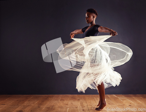 Image of Freedom of expression. Young female contemporary dancer using a soft white white skirt for dramatic effect.