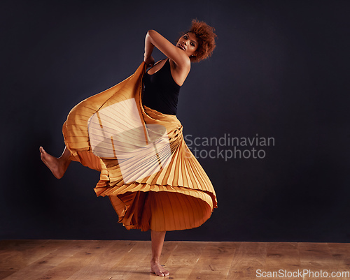 Image of Earth dance. Female contemporary dancer in a dramatic pose against dark background.