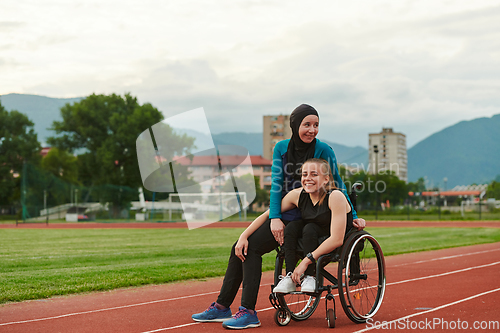 Image of A Muslim woman wearing a burqa resting with a woman with disability after a hard training session on the marathon course