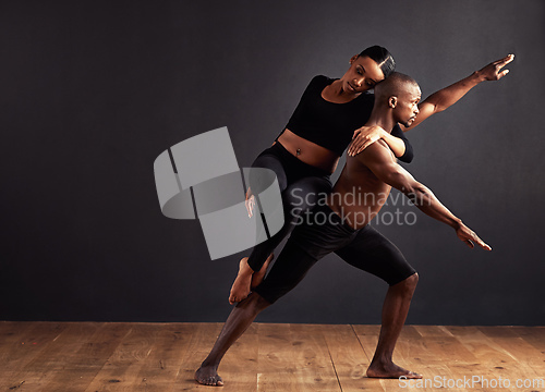 Image of Balance of male and female energies. A female and male contemporary dancer performing a dramatic pose in front of a dark background.