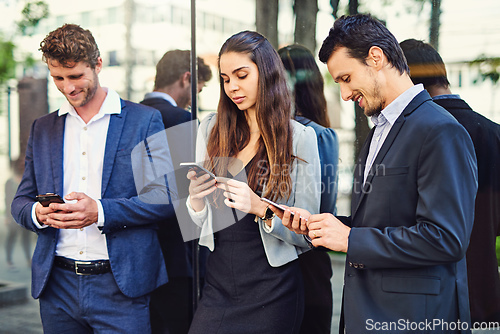 Image of Enjoying some connectivity outside before they attend the seminar. Cropped shot of businesspeople using cellphones outside.