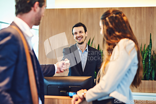 Image of Time to pay for your stay. Cropped shot of a businessman and businesswoman checking into a hotel.