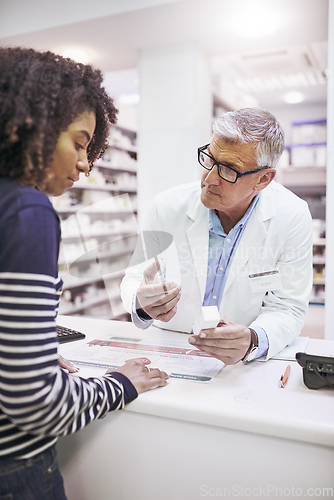 Image of Just take these twice a day. Shot of a dedicated mature male pharmacist giving a customer prescription meds over the counter.