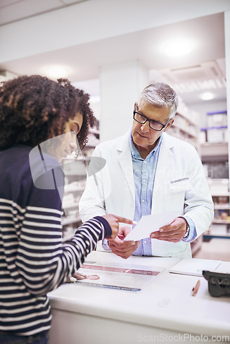 Image of So I only take these twice a day. Shot of a dedicated mature male pharmacist giving a customer prescription meds over the counter.