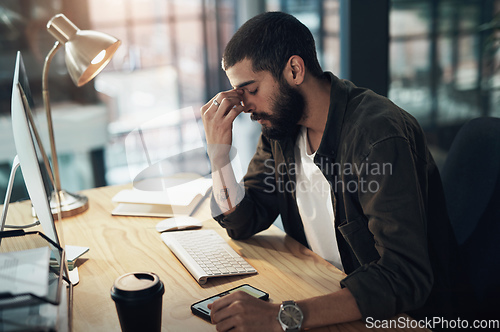 Image of Thats it, Im done. Shot of a young businessman feeling stressed while working late at night in a modern office.