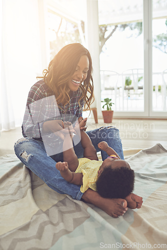 Image of Bonding with her baby. Full length shot of a young mother and her little baby girl at home.