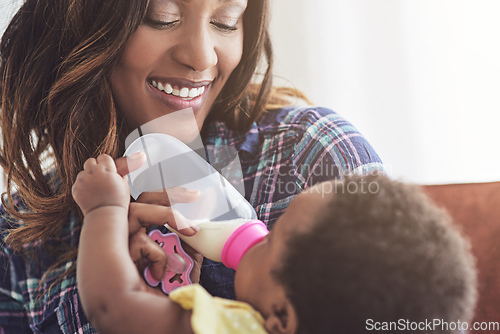 Image of Somebodys hungry. Cropped shot of a young mother feeding her baby girl at home.