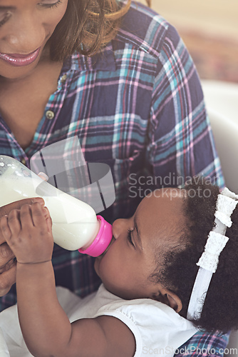 Image of Drink up. Cropped shot of a young mother feeding her baby girl at home.