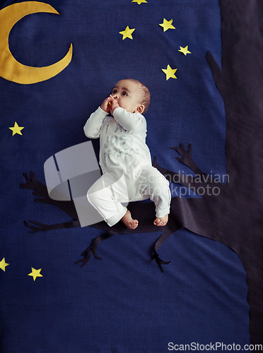 Image of Rock a bye baby on the treetop. Concept shot of an adorable baby boy sitting on a tree against an imaginary night time background.