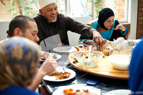 Image of Food brings family together. Shot of a muslim family eating together.