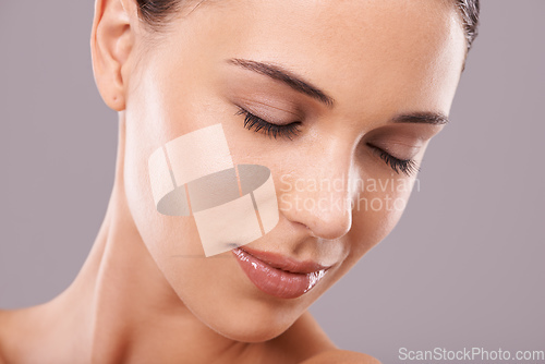 Image of Serene beauty. Beauty shot of a beautiful young woman with perfect skin against a gray background.