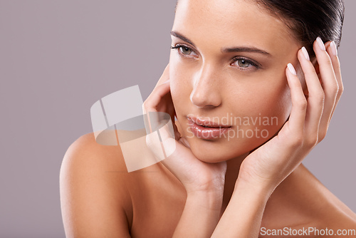 Image of Gorgeous in every way. Beauty shot of a beautiful young woman with perfect skin against a gray background.