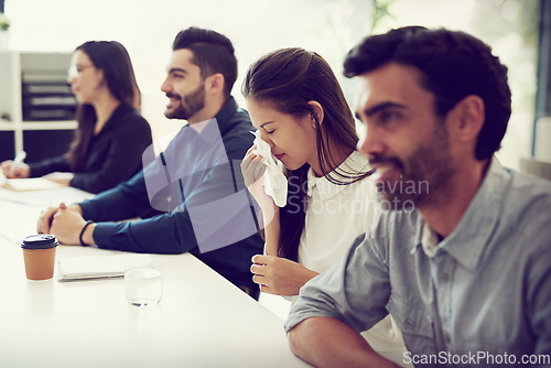 Image of Her sneezes keep interrupting the meeting. Cropped shot of a businesswoman suffering with allergies while sitting in a meeting in an office.