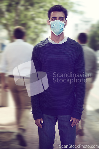 Image of Flu season is here. Shot of a man wearing a surgical mask in a crowd.