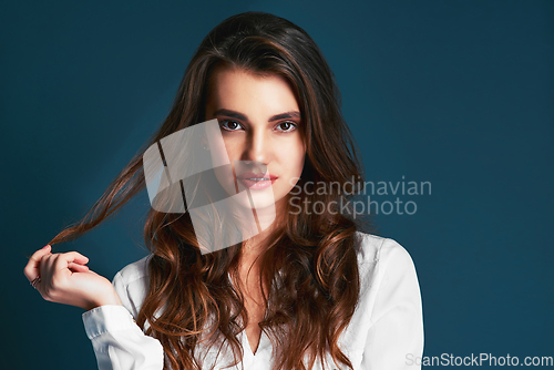 Image of You gorgeous and dont you forget it. Studio shot of an attractive young fashionable woman posing against a blue background.