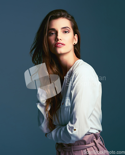 Image of Its all about the perfect pose. Studio shot of an attractive young fashionable woman posing against a blue background.