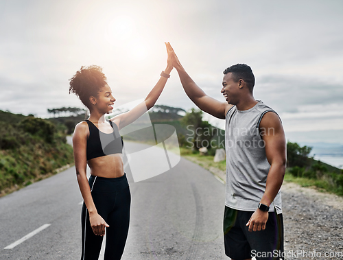 Image of Were crushing so many of our fitness goals. Shot of a sporty young couple high fiving each other while exercising outdoors.