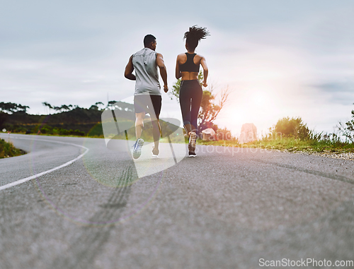 Image of Staying in top form together. Rearview shot of a sporty young couple exercising together outdoors.