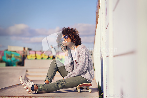 Image of Why walk when you can skate. Shot of a young woman out skateboarding in the city.