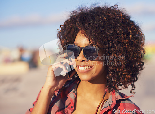 Image of Im here.. wanna meet up. A trendy young african american woman smiling while using her mobile.