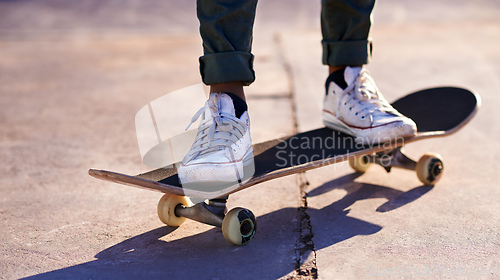 Image of These sneakers were made for skating. A cropped shot of a woman standing on a skateboard.