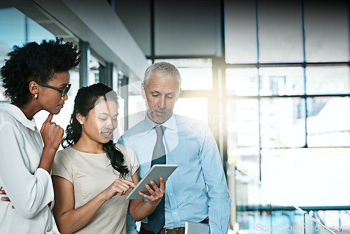 Image of Using technology to take brainstorming to the next level. Shot of a business team using a digital tablet while having an informal meeting.