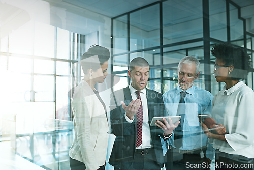 Image of I just need some advice to help me to decide.... Shot of a business team using a digital tablet while having an informal meeting.