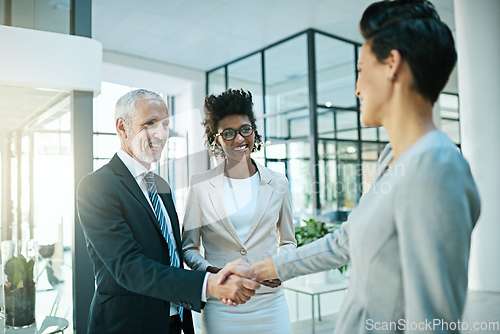 Image of Theyre always happy to add members to the team. Shot of businesspeople shaking hands in an modern office.
