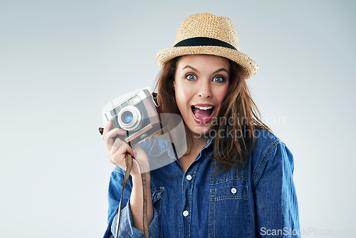 Image of I cant picture a more exciting moment. Studio portrait of a young woman using a vintage camera against a grey background.