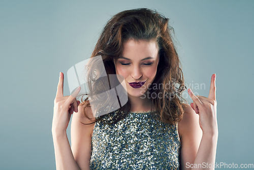 Image of I rock my own style. Studio shot of a young woman making a hand gesture against a grey background.