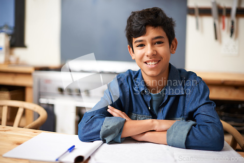 Image of Im top of my class. Portrait of a young boy studying at a desk in a classroom.