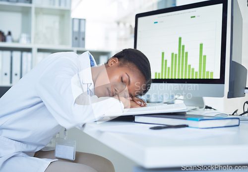 Image of Fighting burnout is half the battle. Shot of a young scientist sleeping at her desk while conducting research in a laboratory.