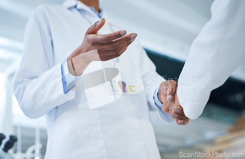 Image of The biggest deal in research and development. Shot of two unrecognisable scientists shaking hands in a laboratory.