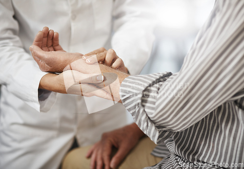 Image of Lets check your pulse. Cropped shot of an unrecognizable female doctor taking a male patients pulse during a consultation.