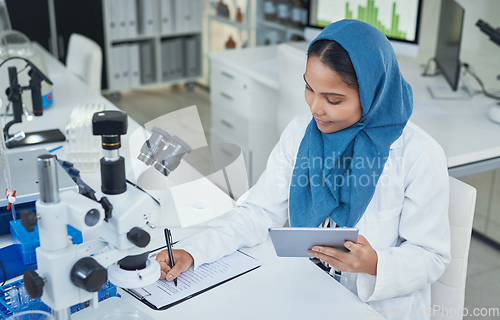 Image of Getting down to life enhancing lab work. Shot of a young scientist using a digital tablet while conducting research in a laboratory.