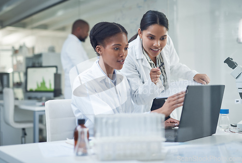 Image of Improving lives one collaboration at a time. Shot of two young scientists using a laptop in a laboratory.