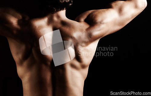 Image of Masculinity in portrait. Studio shot of a muscular shirtless man isolated on black.