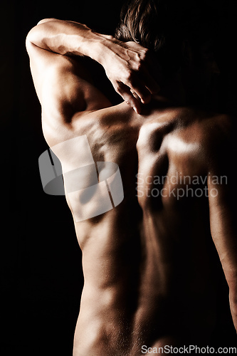 Image of Masculinity in portrait. Studio shot of a muscular shirtless man isolated on black.