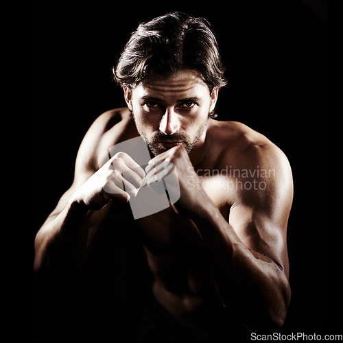 Image of Put your fists up. Portrait of a muscular young boxer standing ready to fight.