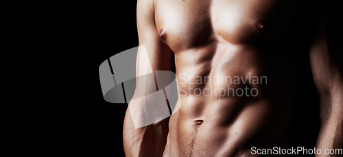 Image of Masculinity in portrait. Studio shot of a muscular shirtless man isolated on black.