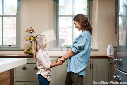 Image of Being a mom means so much to me. Shot of a young girl and her mother dancing in the kitchen at home.