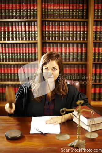 Image of Shes an expert in the legal world. Shot of a young legal professional sitting at her desk in a study.