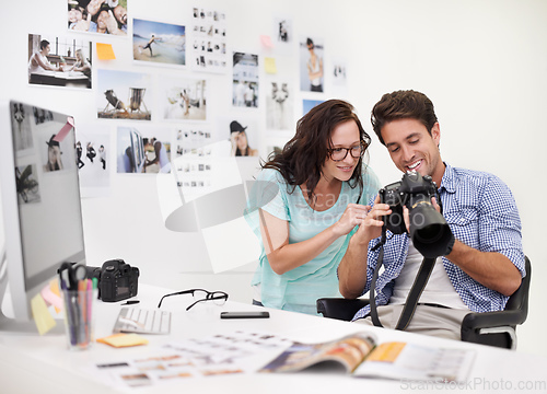 Image of There are some really great images here. A photographer looking at his images in his office with his assistant.