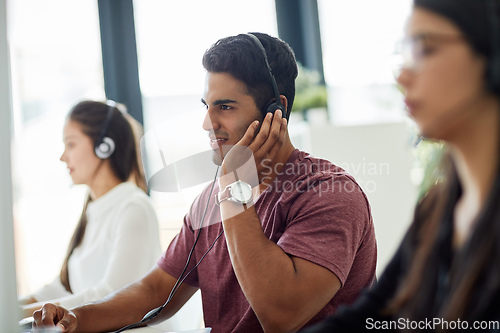 Image of He has top-notch communication skills. Shot of a group of customer service representatives working at a desk.