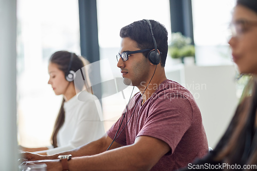 Image of They are on the front line of customer service. Shot of a group of customer service representatives working at a desk.