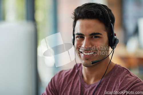 Image of He upholds the trust and faith in his company. Shot of a young call centre agent working at his desk.