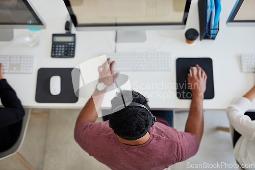 Image of Conveying a solution quickly and effectively. Shot of a young call centre agent working at his desk.