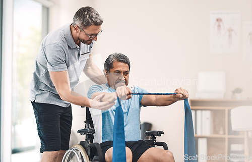 Image of This exercise is also great for maintaining good balance. Shot of a senior man in a wheelchair exercising with a resistance band along side his physiotherapist.