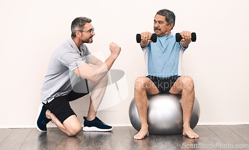 Image of Balance is key in everything in life. Full length shot of a senior man exercising with dumbbells during a rehabilitation session with his physiotherapist.